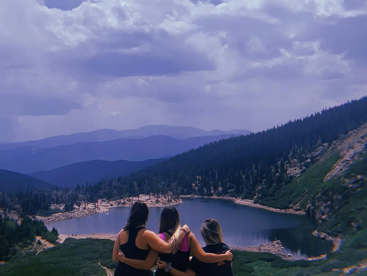 Image of friends from behind showing an amazing mountainous view in the background
